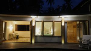 ein Haus mit einer nachts beleuchteten Veranda in der Unterkunft The Mayana Beach House in Selemadeg