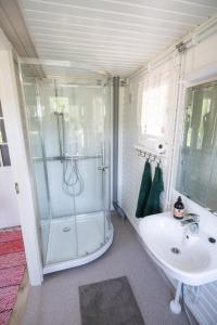 a bathroom with a shower and a sink at Poromoision pirtti in Peurasuvanto