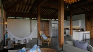 ein Wohnzimmer mit einem Sofa und einer Küche in der Unterkunft The Mayana Beach House in Selemadeg