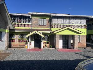 a large brick building with a green at PODLYNS Home in Ngong
