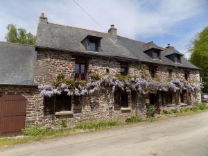 an old brick building with purple flowers on it at Ianrhu in Gaël