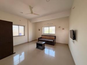 a living room with a couch and a tv at Swami Homestay in Solapur