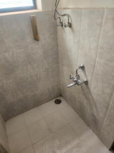 a bathroom with a shower with a tiled floor at Swami Homestay in Solapur