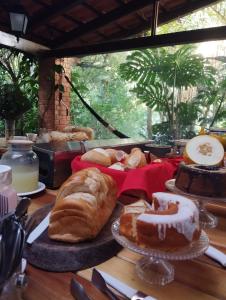 a table topped with different types of bread and pastries at CASA RANXOXITA in Itaipava