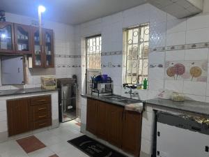 a large kitchen with wooden cabinets and counters at PODLYNS Home in Ngong