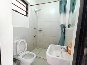 a white bathroom with a toilet and a sink at Starla Apartment in Kinoo +21 photos