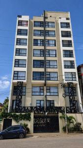a large building with a car parked in front of it at Starla Apartment in Kinoo