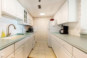 a kitchen with white cabinets and a white refrigerator at Sea Colony oceanfront 4th floor condo with elevator in Bethany Beach