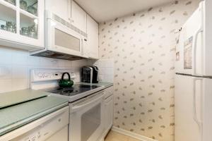a kitchen with white cabinets and a stove top oven at Sea Colony oceanfront 4th floor condo with elevator in Bethany Beach