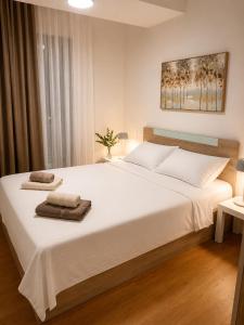 a bedroom with a large white bed with towels on it at SOLU Luxury Apartments with Free Parking ,Fast Wi -Fi, New Building in Skopje +16 photos