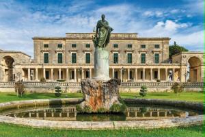 a statue in front of a building with a fountain at Fiore Kampielo Apartment in Corfu
