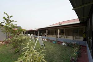 a building with a yard with a sign in front of it at Raj Garden Resort in Guwahati +5 photos