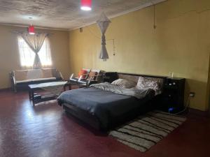 a bedroom with a bed and a couch in a room at PODLYNS Home in Ngong