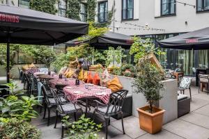 a restaurant with tables and chairs and umbrellas at Hotel AMANO Grand Central in Berlin