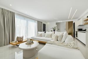 a white living room with a white couch and a table at Sole Azzurro Villas in Kanali
