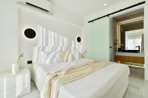 a white bedroom with a large bed and a mirror at Sole Azzurro Villas in Kanali +62 photos