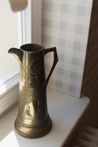 a bronze vase sitting on a window sill at JETHON Appartement am Wasserturm 1 in Nienburg