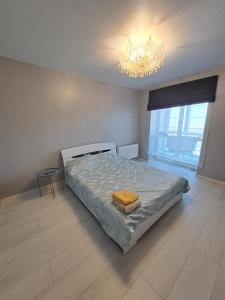 a bedroom with a large bed and a chandelier at Яровиця 9699 in Lutsk