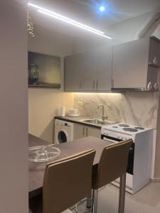 eine Küche mit weißen Schränken und einem Tisch mit Stühlen in der Unterkunft Rea Harmony in Kalamata + 39 Fotos