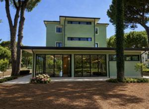 a green house with glass doors and trees at Hotel Venus in Milano Marittima