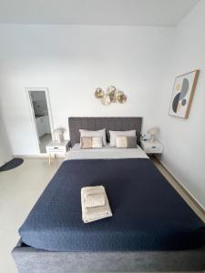 a bedroom with a large bed with a blue blanket at Aivalis corner in Ierapetra
