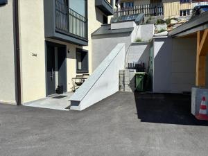 a white stair case in a building next to a building at Mountain spot in a cozy nest in Airolo