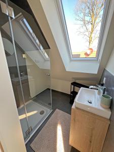 a bathroom with a sink and a skylight at FiO Ferienhäuser - Ferien in Ohne in Ohne +51 photos