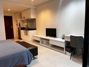 a bedroom with a bed and a desk with a television at The Pixel Sri Panwa, Phuket in Ban Ao Makham