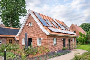 a house with solar panels on the roof at FiO Ferienhäuser - Ferien in Ohne in Ohne