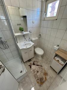 a bathroom with a toilet and a sink and a shower at Apartments Neda in Primošten