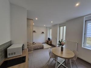 a living room with a table and a bedroom at La terrasse du palais in Metz
