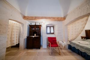 a bedroom with a bed and a red chair at Casa del Ramaiolo in Alberobello