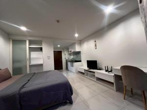 a bedroom with a bed and a desk with a computer at The Pixel Sri Panwa, Phuket in Ban Ao Makham
