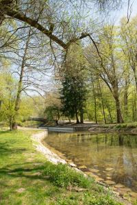 a river in a park with trees and grass at Munich Oktoberfest Bavarian Camping Village with breakfast & welcome beer in Munich