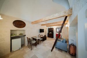 a kitchen and dining room with a table and chairs at Casa del Ramaiolo in Alberobello