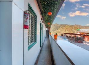 a balcony of a building with plants on the side at Hotel Amar in Mussoorie
