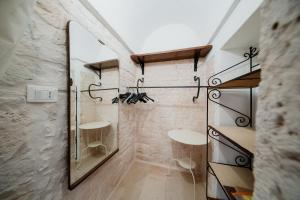 a bathroom with a mirror and two shelves at Casa del Ramaiolo in Alberobello +19 photos