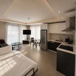 a kitchen and living room with a bed in a room at Calis Suites Çeşme - Only Family in Çeşme