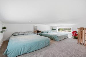 two beds in a white room with a window at Huckleberry Inn in Custer