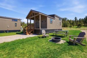 a tiny house with a picnic table and benches at Huckleberry Inn in Custer