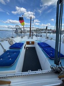 a boat with blue seats on the deck at Schlafplatz mit Meerblick in Kühlungsborn