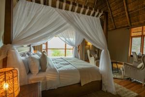a bedroom with a canopy bed with a window at Kidepo Wilderness Lodge in Loitanit