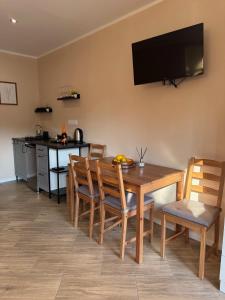 a dining room with a table and chairs and a television on the wall at Dom na wsi in Chmielno
