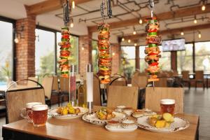 une table avec des assiettes de nourriture et des verres de bière dans l'établissement Hotel Na Błoniach, à Bielsko-Biała