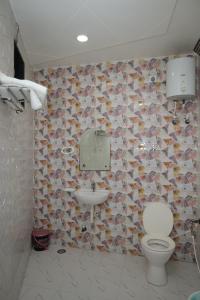 a bathroom with a toilet and a sink at Hotel SR Siddhivinayak Mathura in Mathura