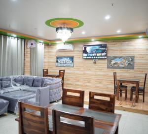 a living room with a couch and a table and chairs at Hotel Arijika View in Kullu Manali