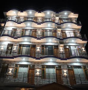 a building with balconies and lights on it at Hotel Arijika View in Kullu Manali