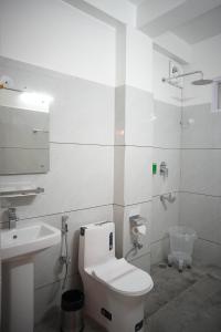 a white bathroom with a toilet and a sink at Hotel Arijika View in Kullu Manali +26 photos