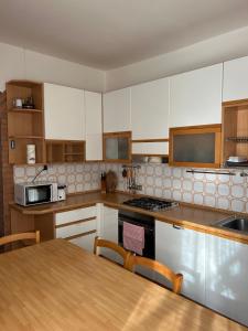 a kitchen with white cabinets and a wooden table at Villa Angela in Dorio