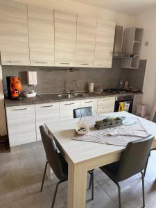 eine Küche mit Tisch, Stühlen und Spüle in der Unterkunft Collis Iani - Experience in Colliano